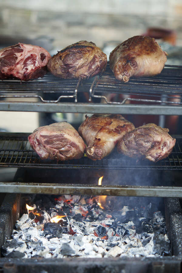 Lamb shoulders slow roasting over hot coals