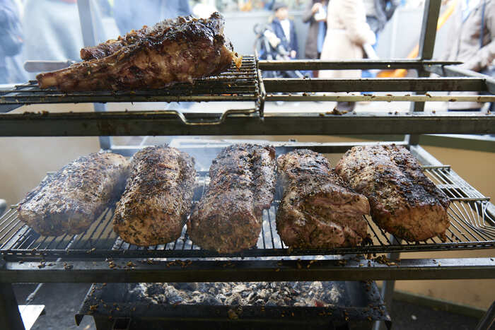 Multiple joints roasting on tiered grill rack at Borough Market